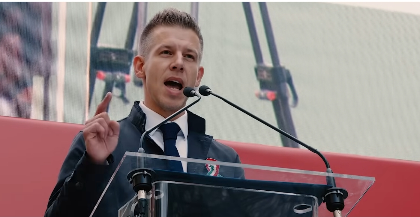 Magyar Péter a Nemzeti Menet élén vonul a tömeggel Budapest utcáin, miközben a háttérben lobogó nemzeti zászlók és a változást követelő feszült, de elszánt hangulat jelzi a politikai áttörés pillanatát.