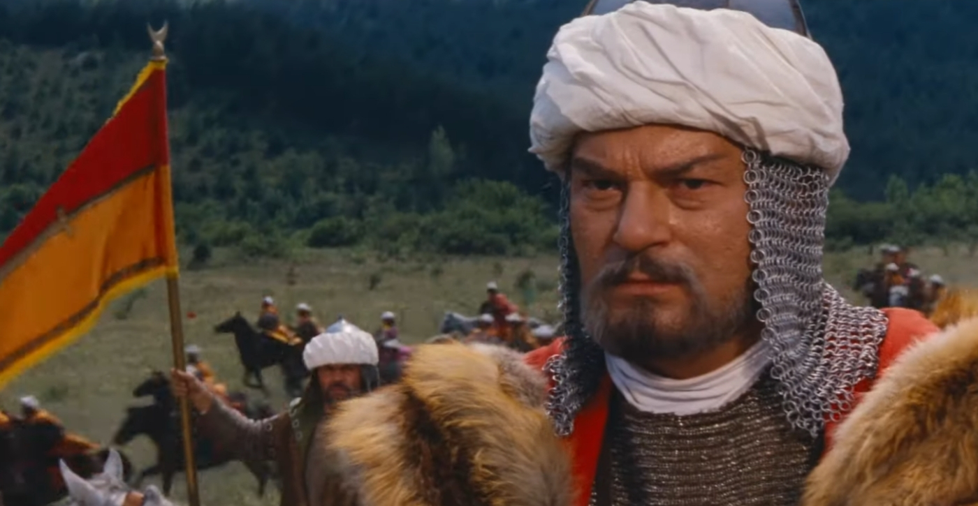 Dobó István várkapitány elszánt tekintettel néz farkasszemet a jövővel, miközben a háttérben felsejlő magyar zászló és a könyvespolc az egri várvédők rendíthetetlen tudását és történelmi erejét jelképezi.