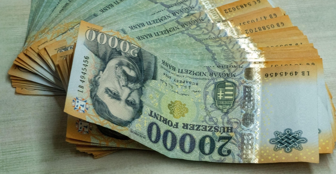 Egy köteg húszezer forintos bankjegy az asztalon, amely a sikeres karrierváltás utáni magas fizetés és a pontos bankszámla jóváírás szimbóluma.