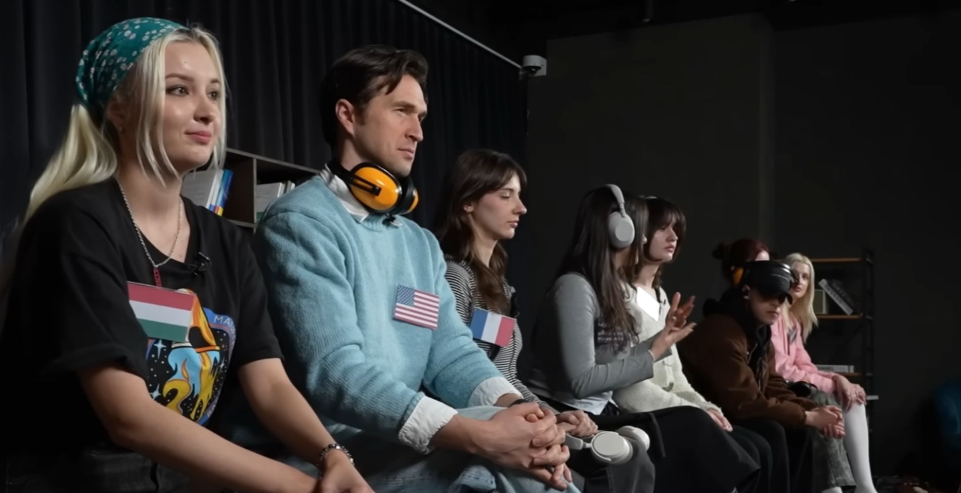 Magyar szavak kiejtésével kísérletező nemzetközi csoport egy videós láncreakcióban, ahol különböző országok képviselői próbálják átadni egymásnak a hallott kifejezéseket.